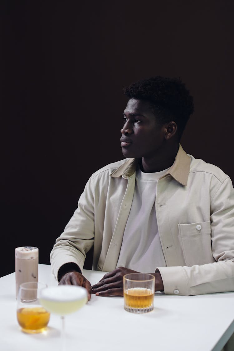 A Man In White Long Sleeves Holding A Glass Of Drink