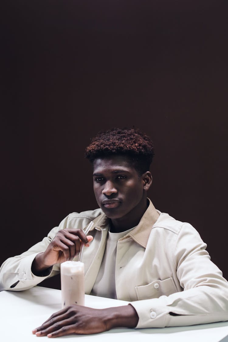 A Man In White Long Sleeves Holding A Glass Of Drink