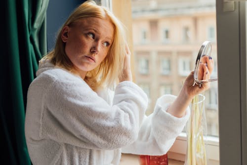 Woman in White Sweater Holding Black Sunglasses