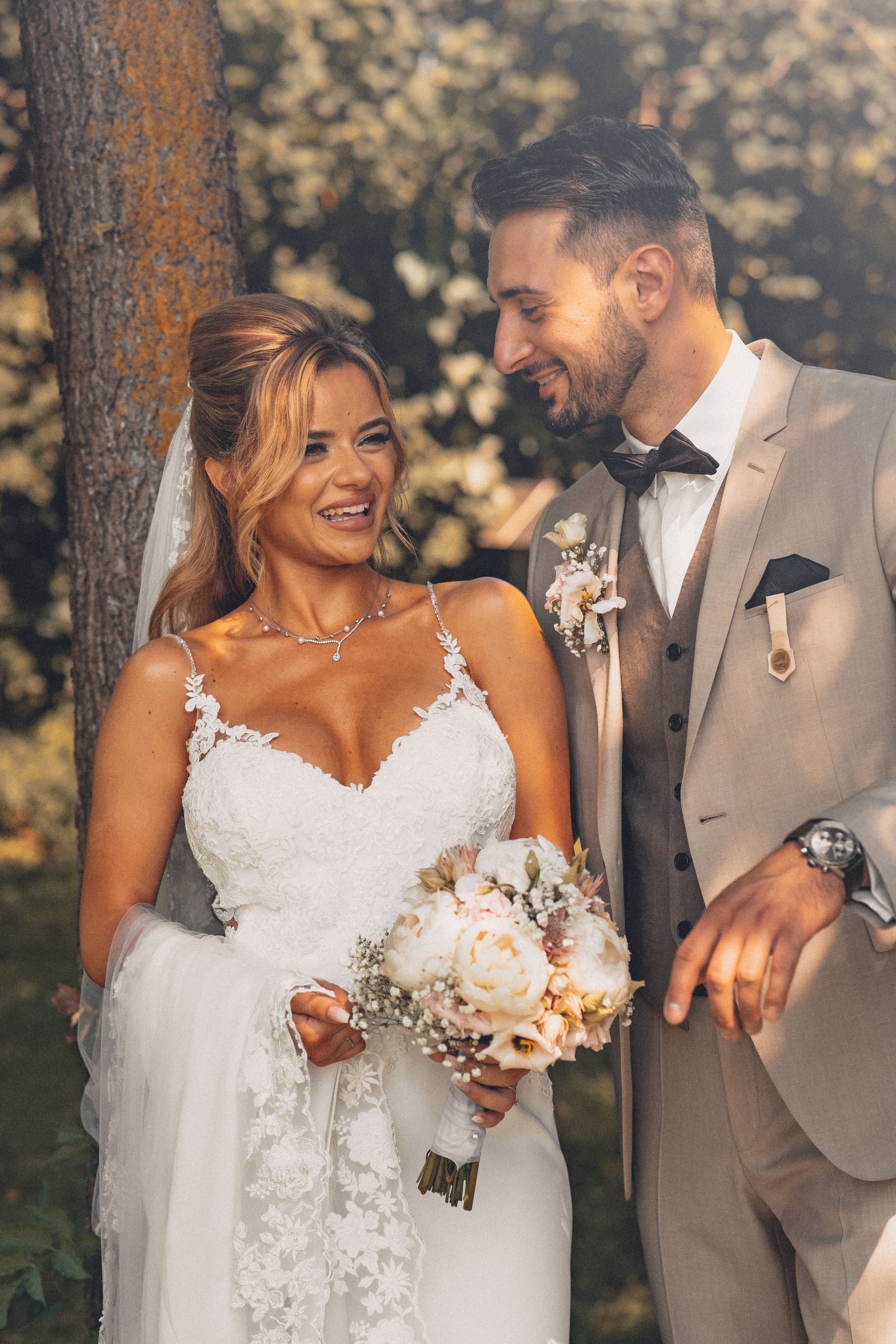 Happy couple sharing a romantic moment on their wedding day captured in natural daylight.