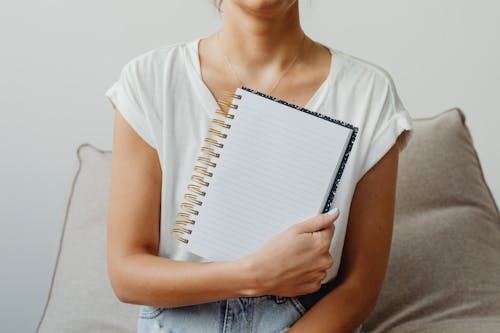 Unrecognizable Woman Holding a Notebook