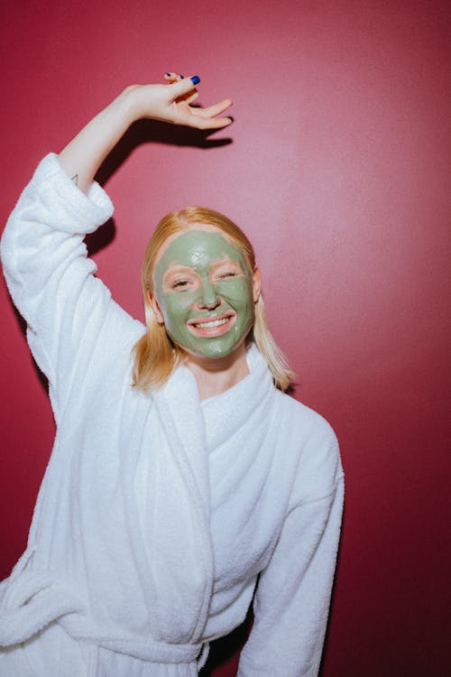 Woman in Bathrobe with Facial Cream on Face