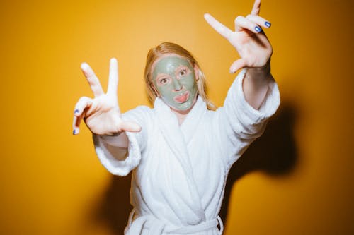 Woman with Cosmetic Mask Wearing Bathrobe