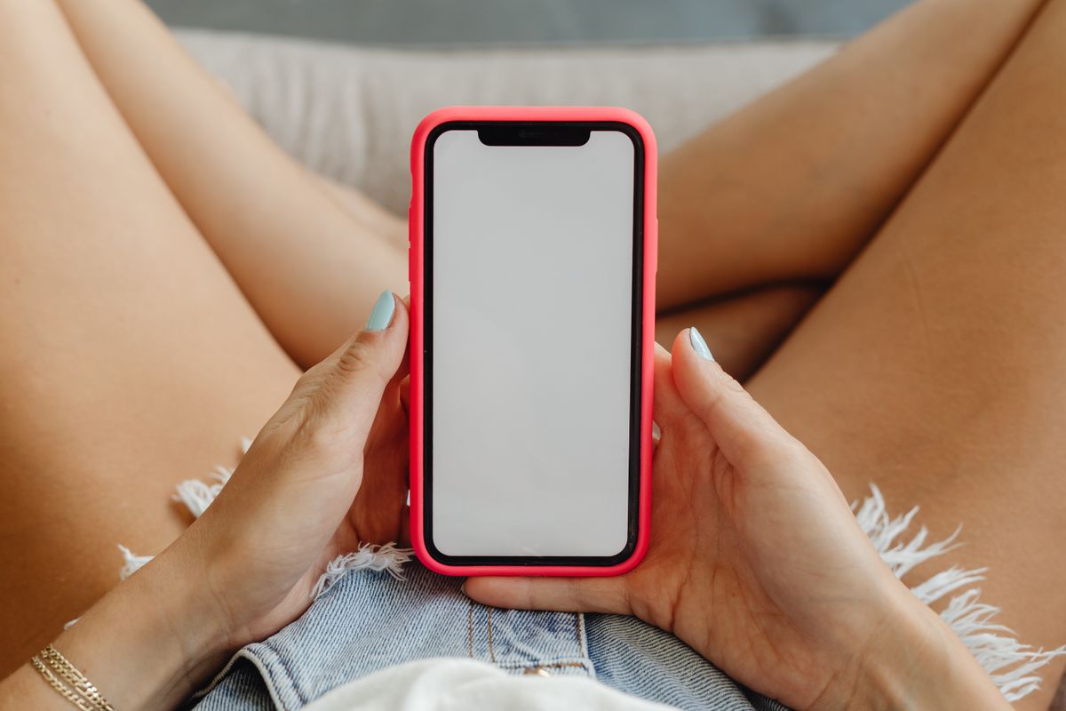 Elde tutulan akıllı telefon ekranında bahis uygulaması açık
