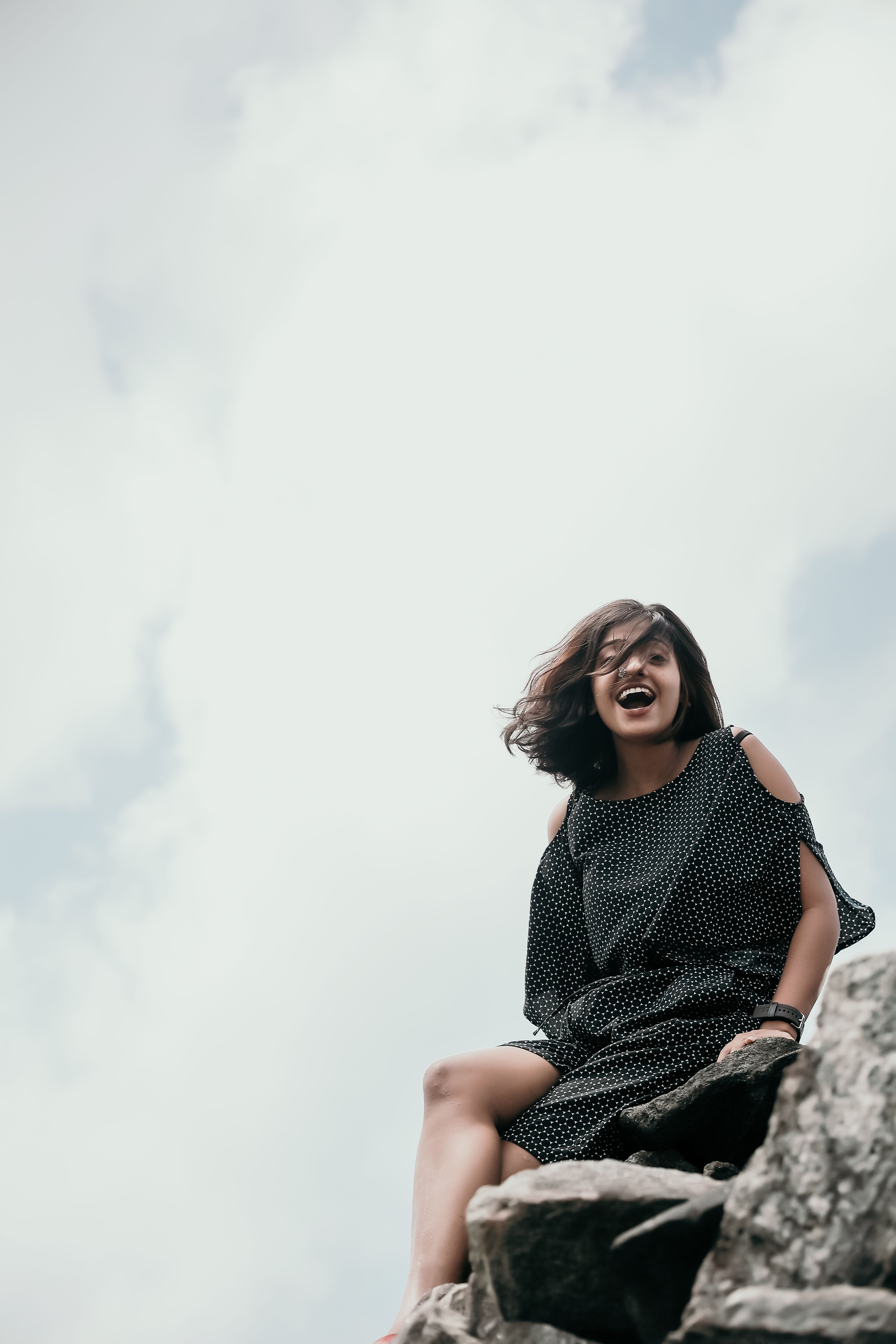 A Woman in Black Dress Sitting on Rocks · Free Stock Photo