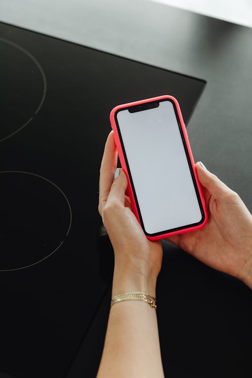 Free Person Holding Smartphone with Red Case Stock Photo