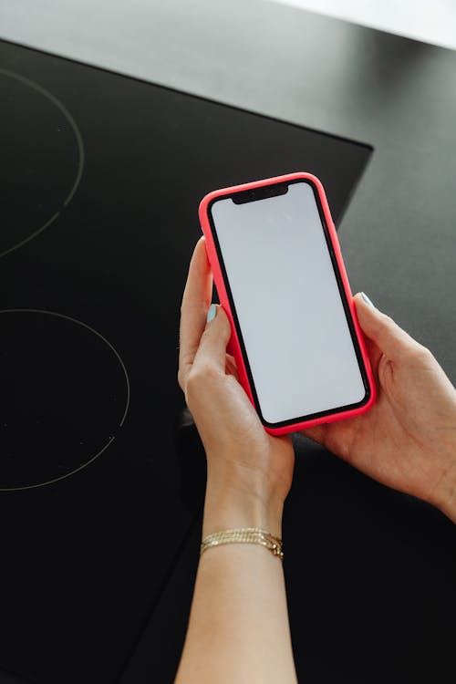 Person Holding Smartphone with Red Case