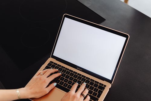 Free Hands typing on a laptop with a blank screen, perfect for mockup or design presentations. Stock Photo