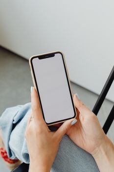 A woman holding a smartphone with a blank screen, perfect for app mockups or presentations.
