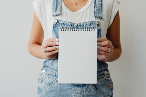 A Person Holding a Blank Notepad