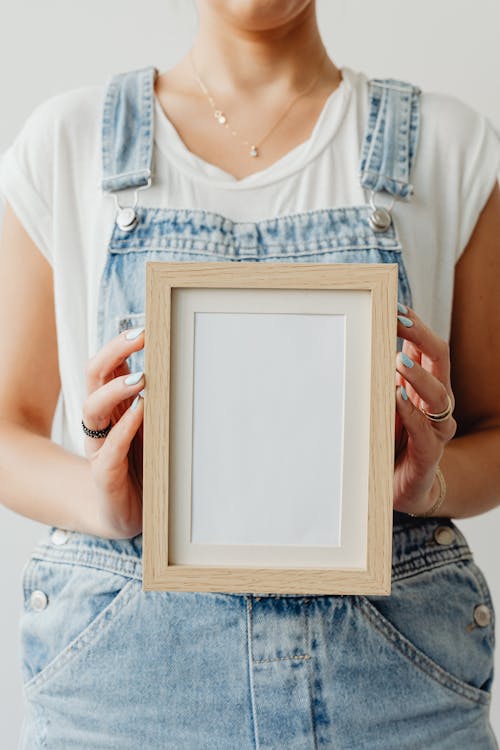 A Person Holding an Empty Picture Frame 