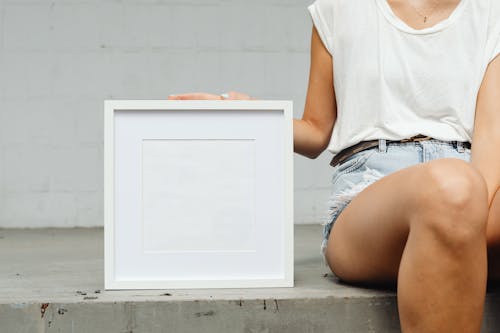 Person Holding a White Frame