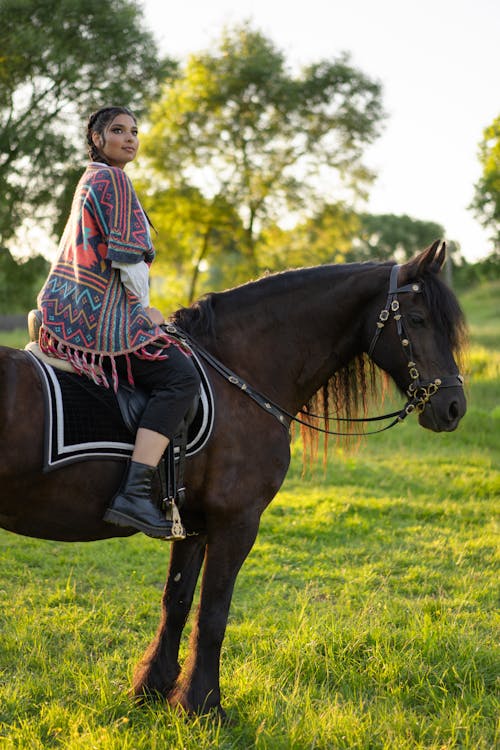 Woman Riding a Horse on Green Grass Field