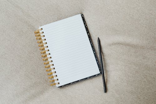 Free A Blank Notebook and a Pencil Stock Photo