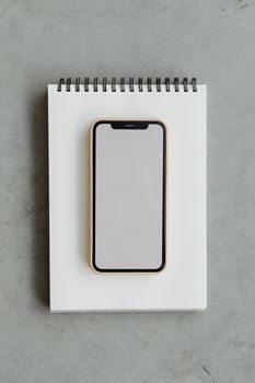 Minimalist smartphone mockup on a notepad, perfect for design projects.