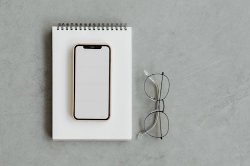 Free A Mobile Phone on Top of a Notepad Stock Photo