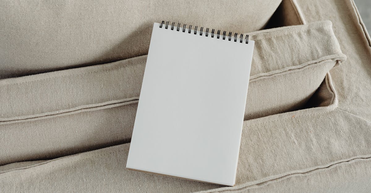 A blank spiral notepad placed on a beige sofa, perfect for mockup or design presentations.