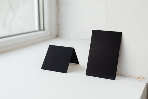 Free Two black cards placed on a white windowsill, perfect for mockup and design presentations. Stock Photo