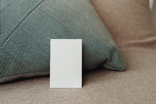 Stylish close-up mockup of a white card against a textured pillow background, offering ample copy space.