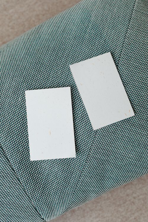 Free Two blank business cards on green textured fabric surface, perfect for branding mockups. Stock Photo