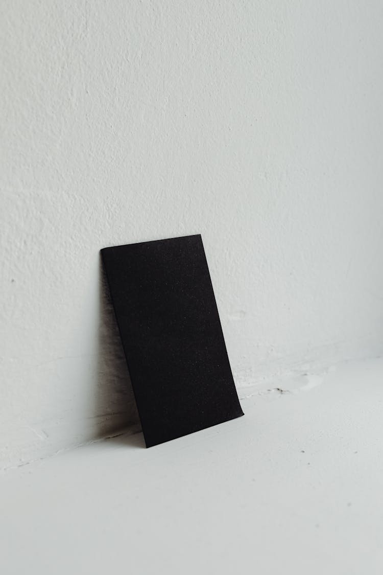 Black Paper Leaning On White Wall