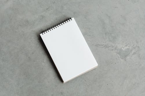 Empty Spiral Note Pad on Concrete Floor