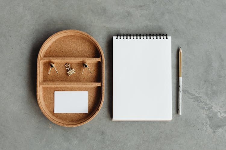 Spiral Notebook Beside Cork Tray And Pencil