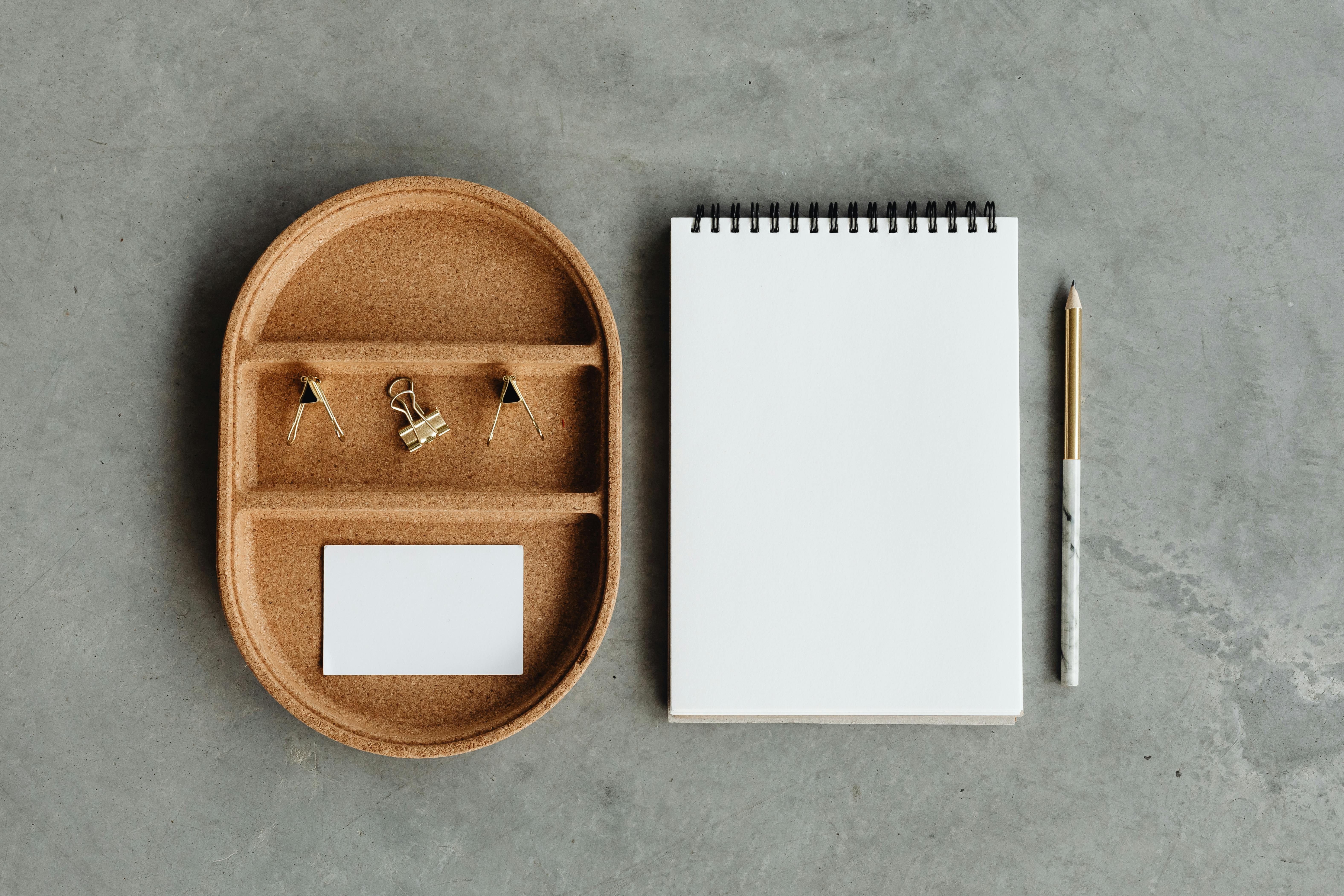Spiral Notebook Beside Cork Tray and Pencil