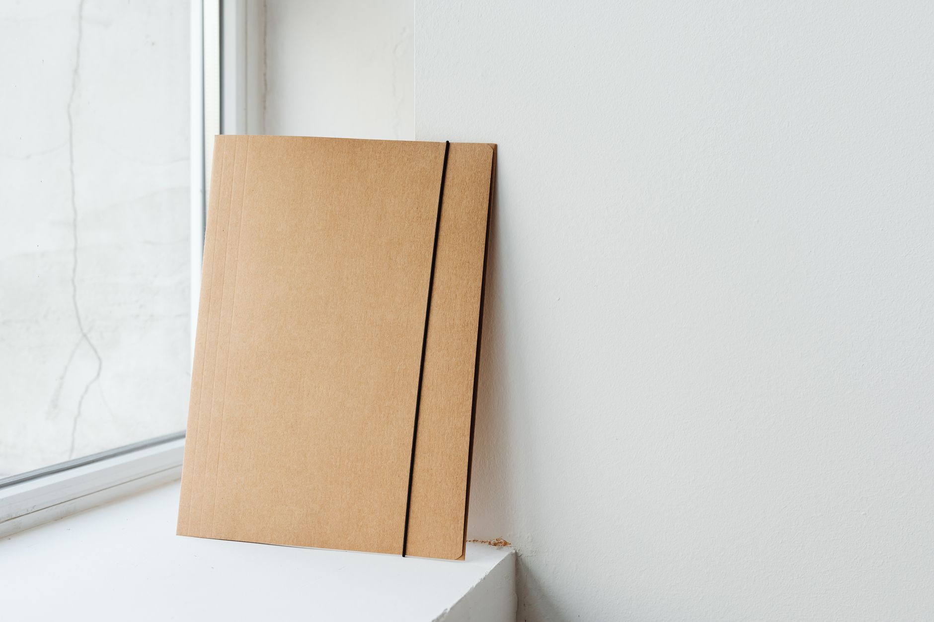 최적의 와이파이 환경을 위한 공유기 설치 전략 8 A simple cardboard folder placed by a window, ideal for creative mockups.