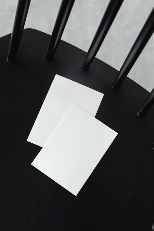 Free Empty White Paper Sheets on a Black Chair  Stock Photo