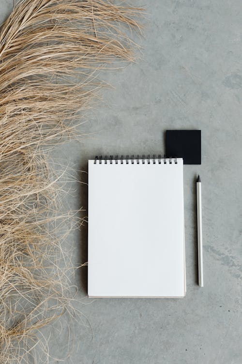 Free White Notebook on White Textile Stock Photo