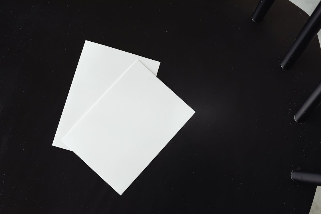 Empty White Paper Sheets on a Black Chair 