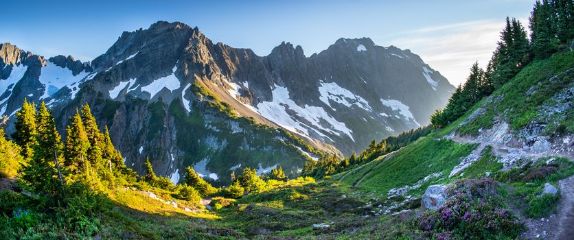 Breathtaking view of North Cascades mountains with snowcaps and vibrant greenery during the day.