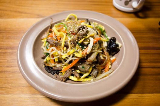Savory stir-fried noodles topped with vegetables and sesame seeds, perfect for a flavorful meal.