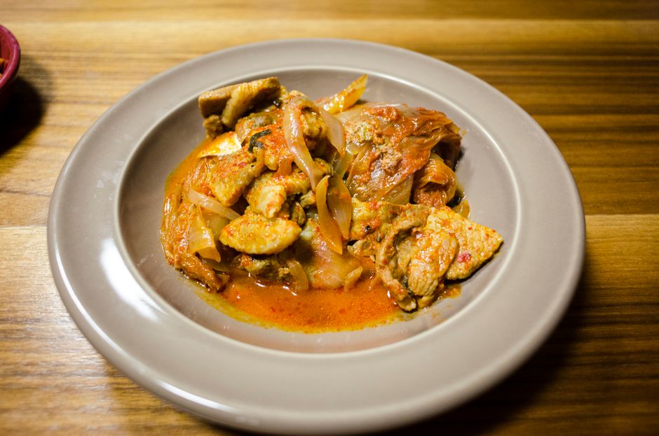Delicious spicy chicken stew with vegetables served on a ceramic plate for dinner.