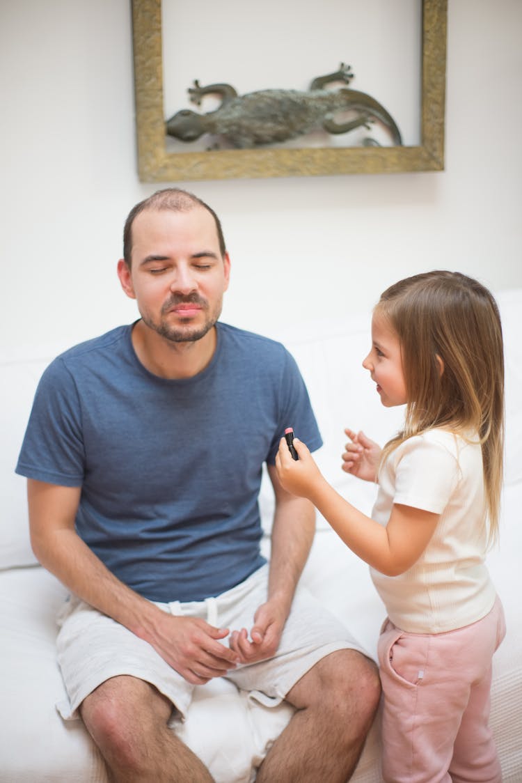 Photo Of A Girl Putting Makeup On Her Father