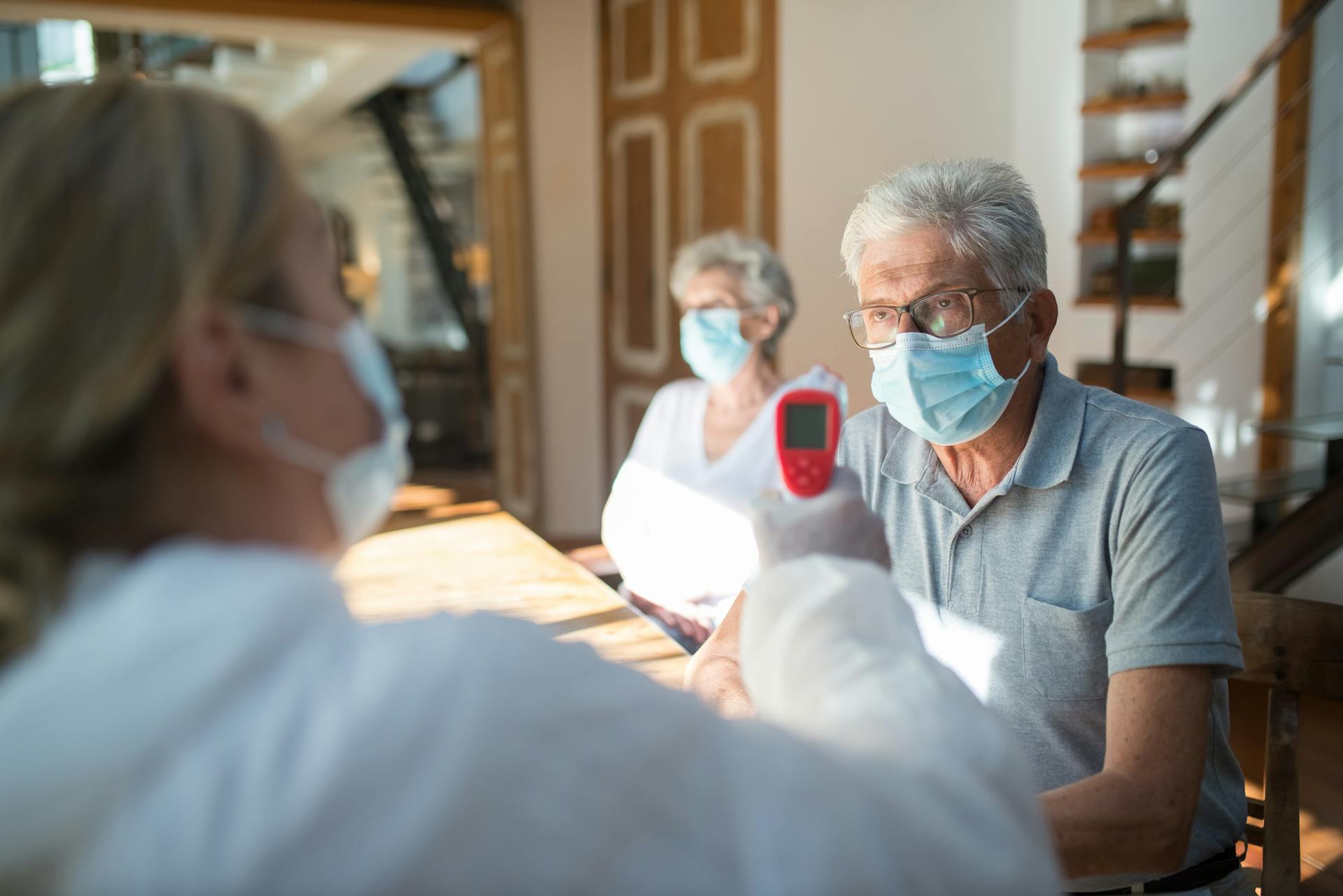 A Doctor Taking the Temperature of an Elderly Man