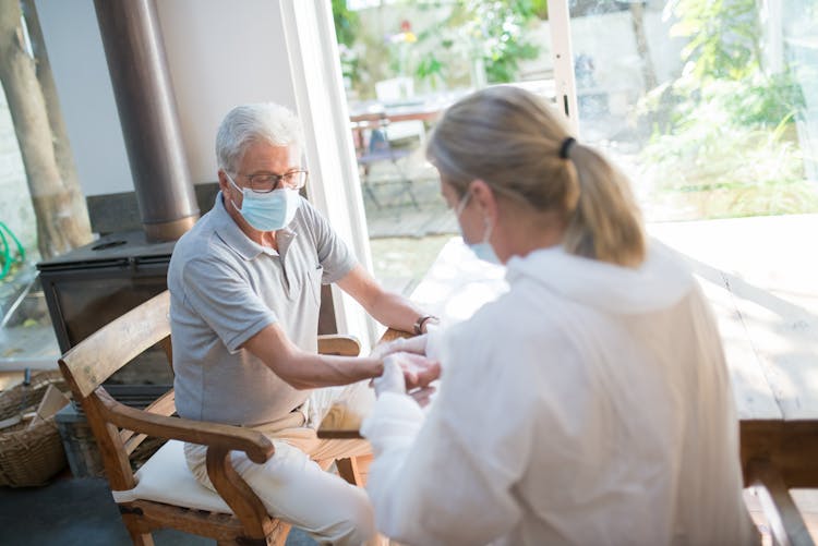 A Doctor Doing A Medical Examination On An Elderly Man At Home