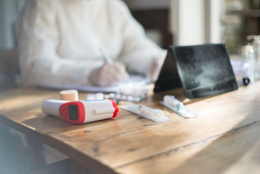 Healthcare worker organizing medical supplies on a desk indoors.