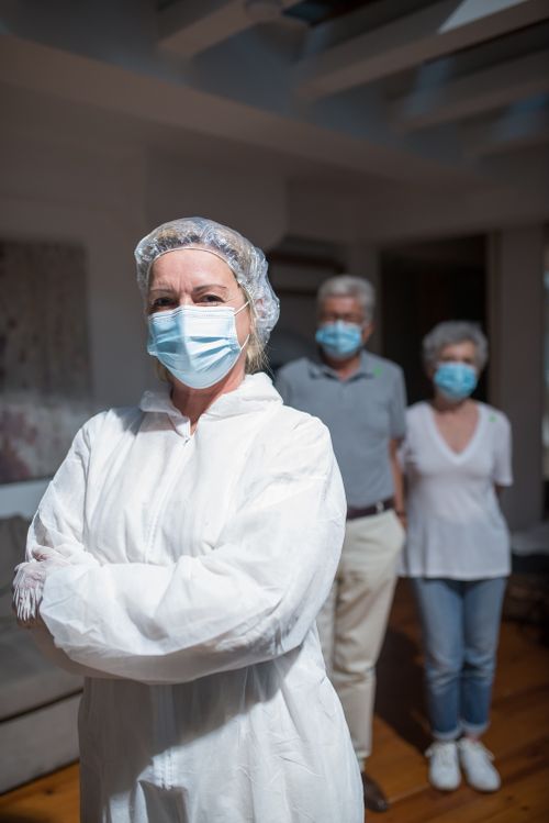 Free Healthcare professional in PPE with elderly patients, emphasizing safety and care. Stock Photo