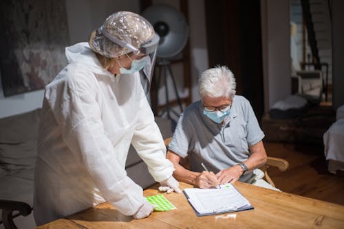 Patient Signing Papers Next to a Doctor