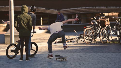 Uomo In Camicia Bianca Facendo Trucco Con Lo Skateboard