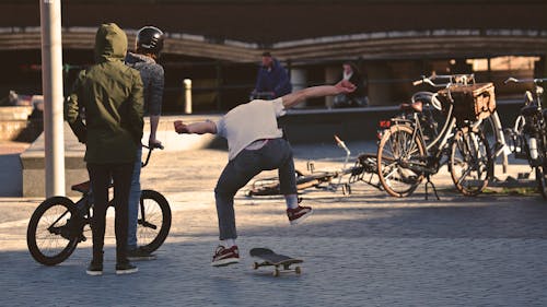 Homme En Chemise Blanche Faisant Un Tour De Planche à Roulettes