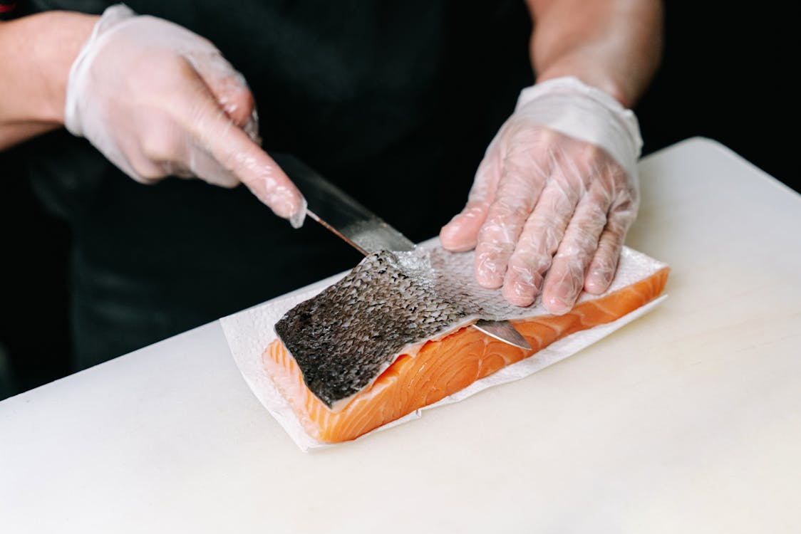 Free A Person Skinning a Salmon Stock Photo