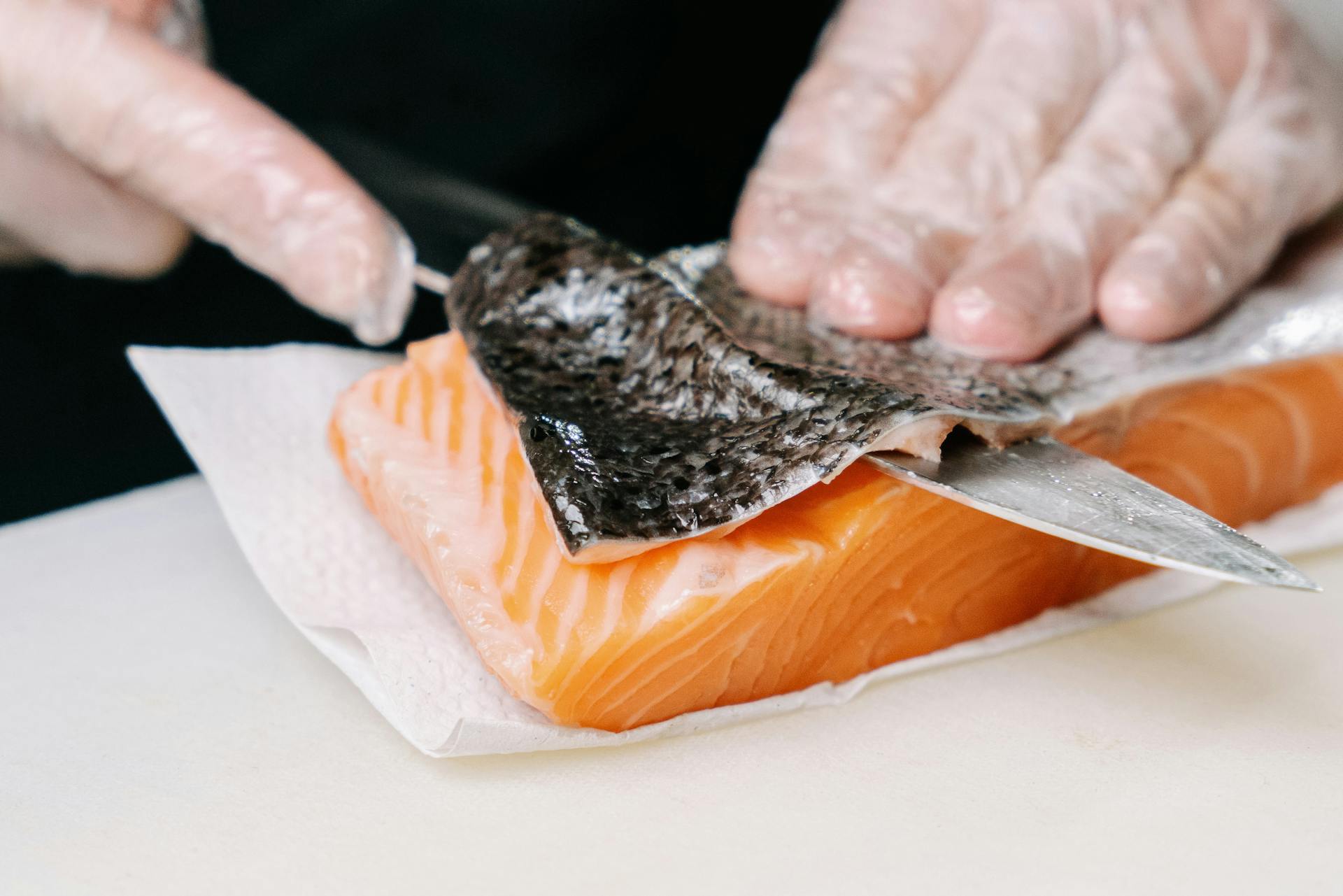 A Person Removing the Skin of a Salmon