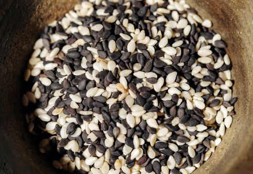 Free A detailed close-up of black and white sesame seeds in a rustic bowl, perfect for healthy food themes. Stock Photo