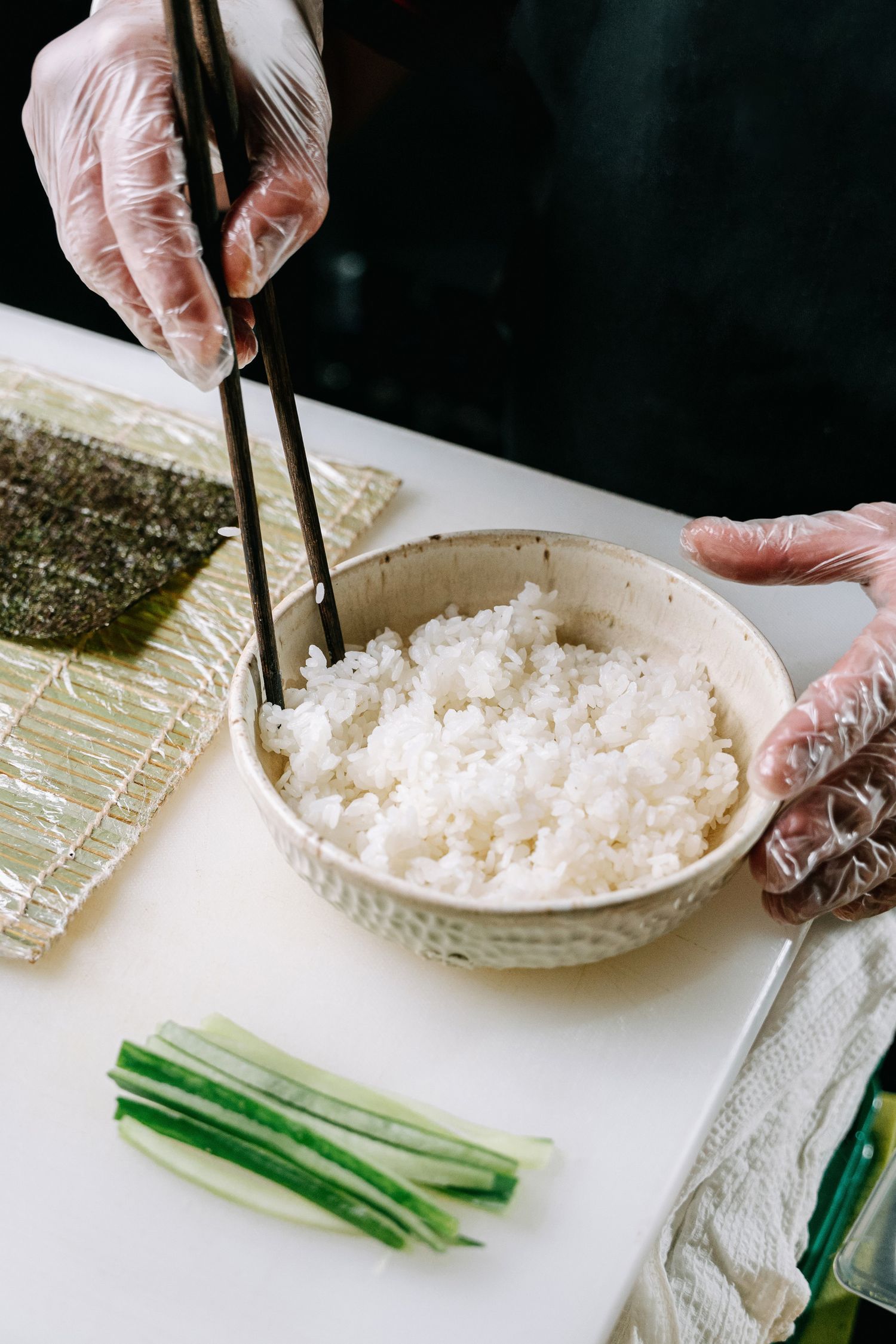Chef preparing sushi with seaweed and rice