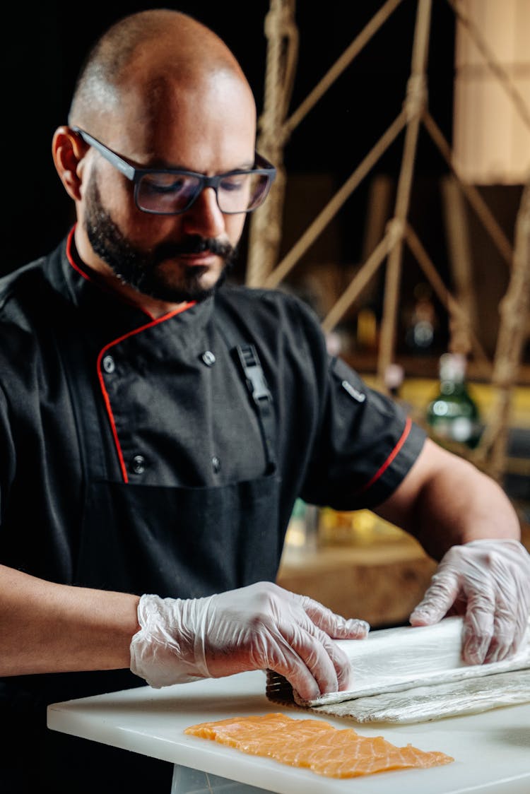 A Male Chef Making A Sushi