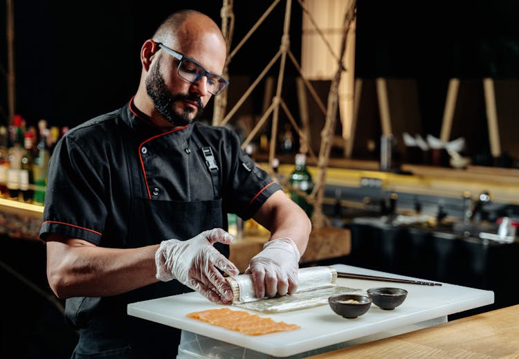 A Male Chef Making A Sushi