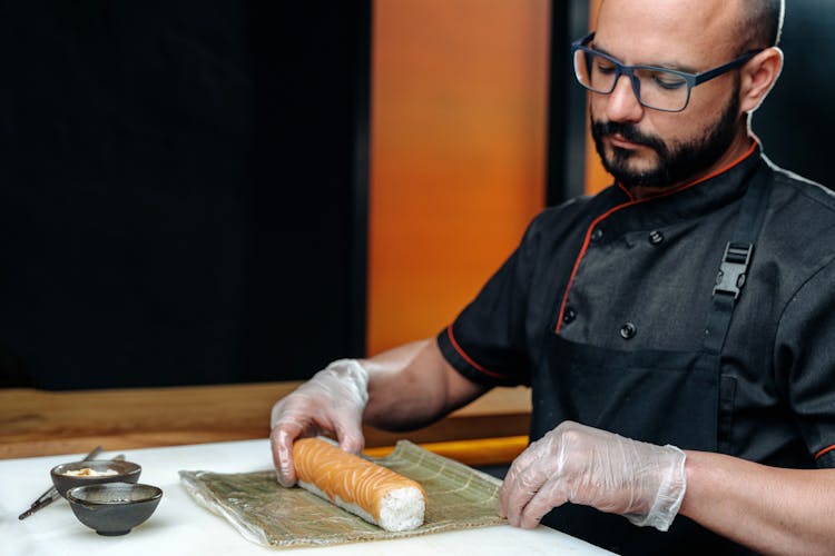 A Male Chef Making A Sushi